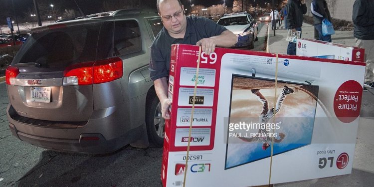 A man drags a big screen TV