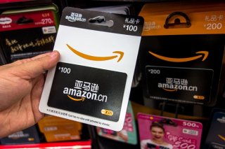 a person looks at an Amazon present card, mainly used for online shopping, at a supermaket.