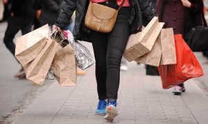 woman walking down road with shopping bags